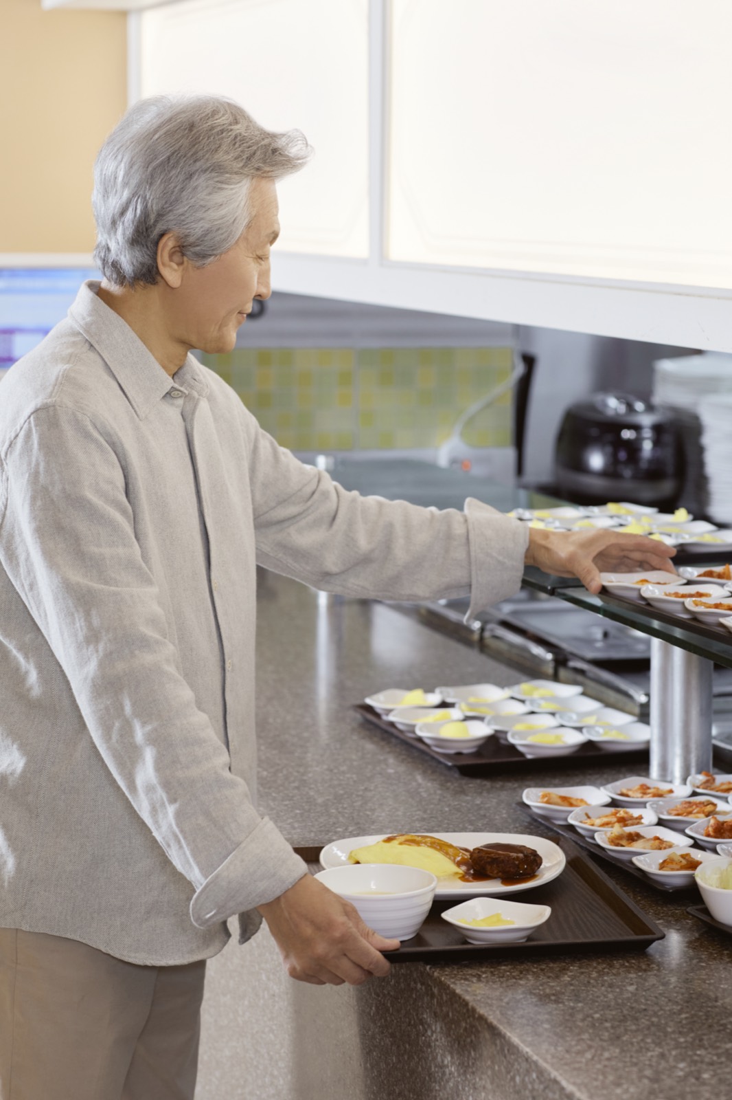 구내식당 배식대에서 식판에 음식을 담는 모습