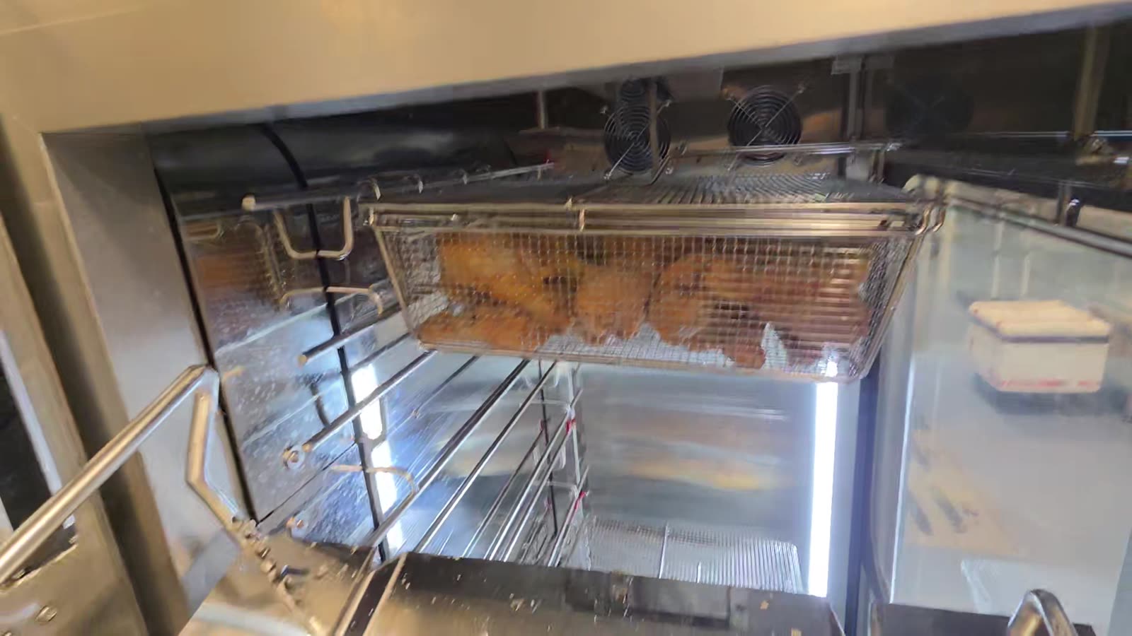 A basket moving up the automated feed lift inside the machine